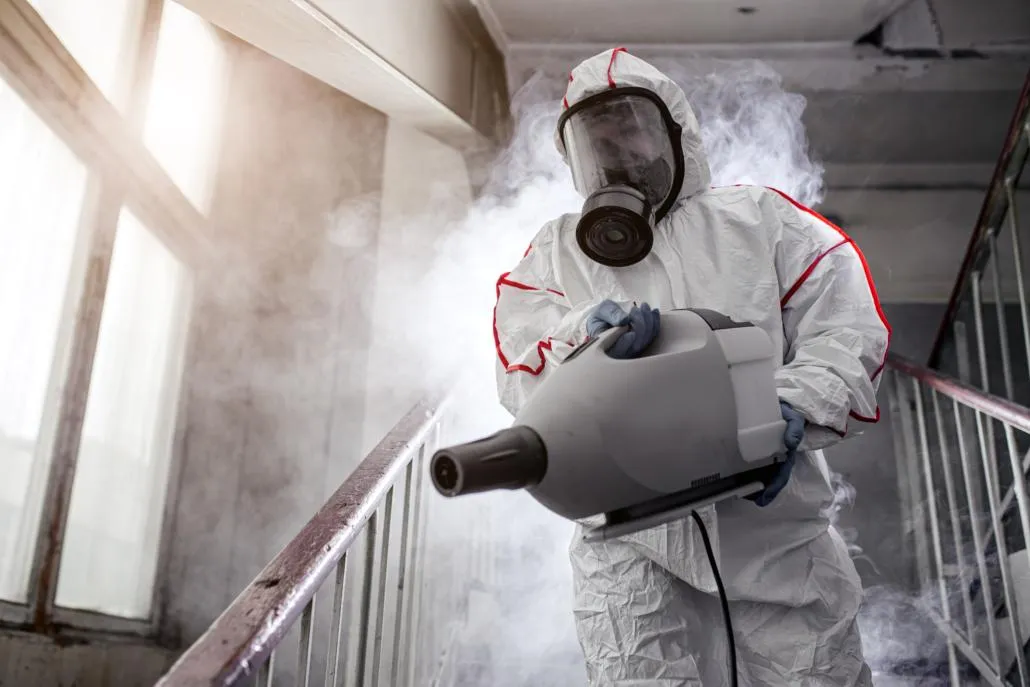 Professional fogging a room with chemicals for odor control and disinfection.