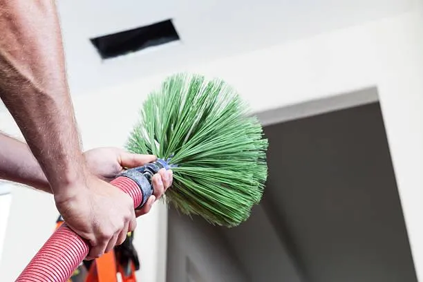 VHrestoration technician holding an air duct cleaning tool, ready to provide professional air duct cleaning services for enhanced air quality.