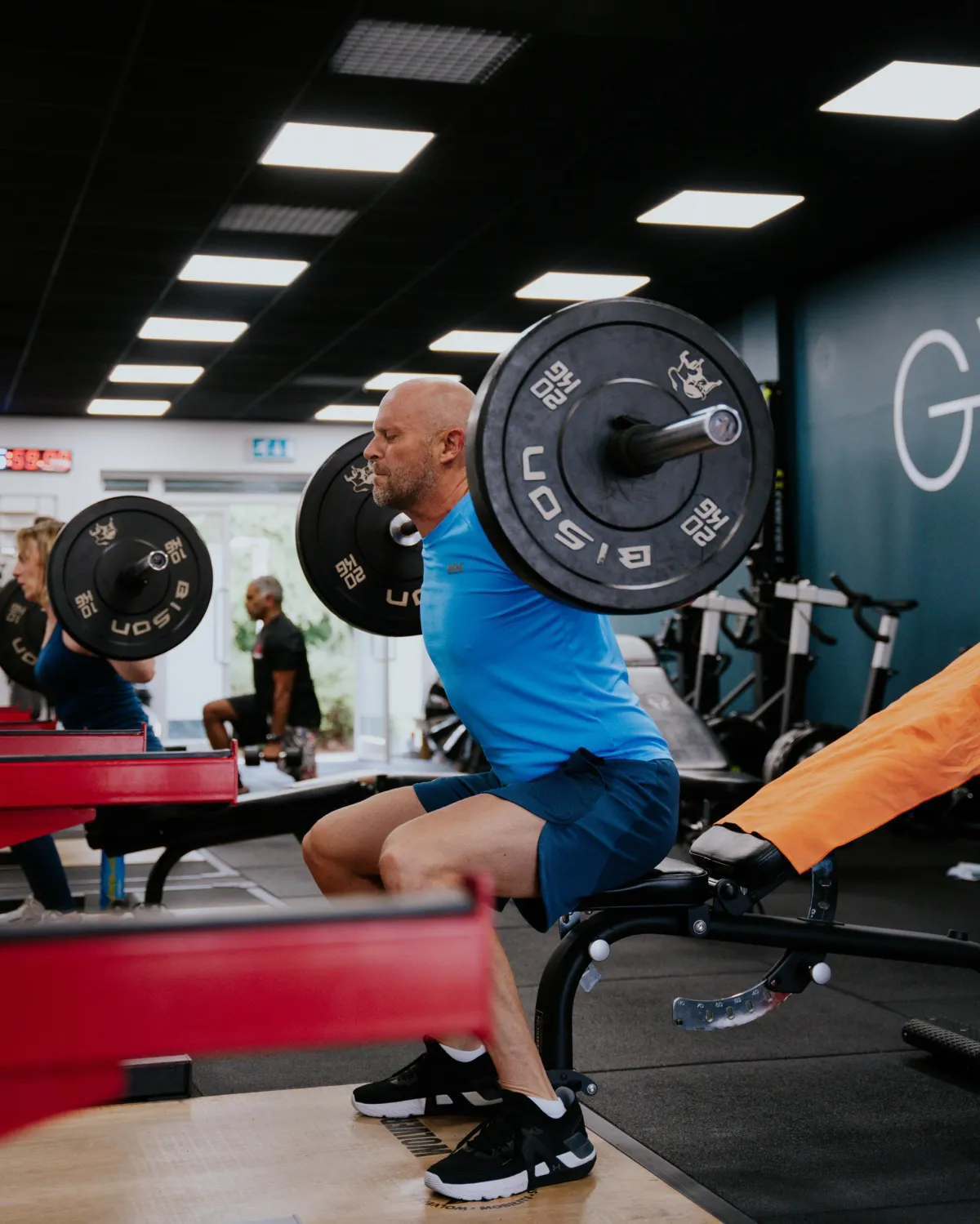 woman in black shirt and blue denim jeans sitting on black exercise equipment