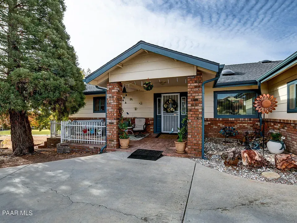 Front view of single-family home at 10701 E Stirrup High Dr W, Dewey, AZ 86327 — featuring landscaped yard, attached garage, and scenic Arizona backdrop.