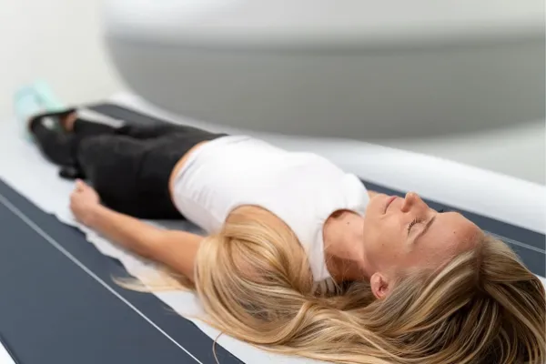 woman on a DEXA scan table undergoing  DEXA bone density scan at DexaFit
