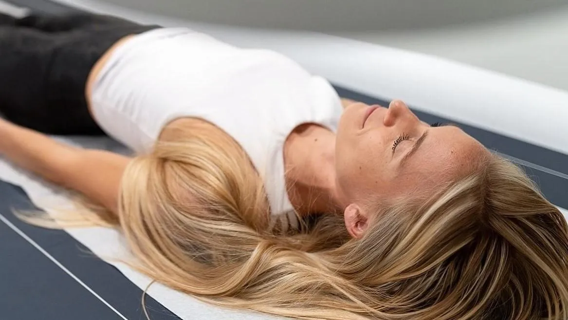 woman on a DEXA scan table undergoing  DEXA bone density scan at DexaFit