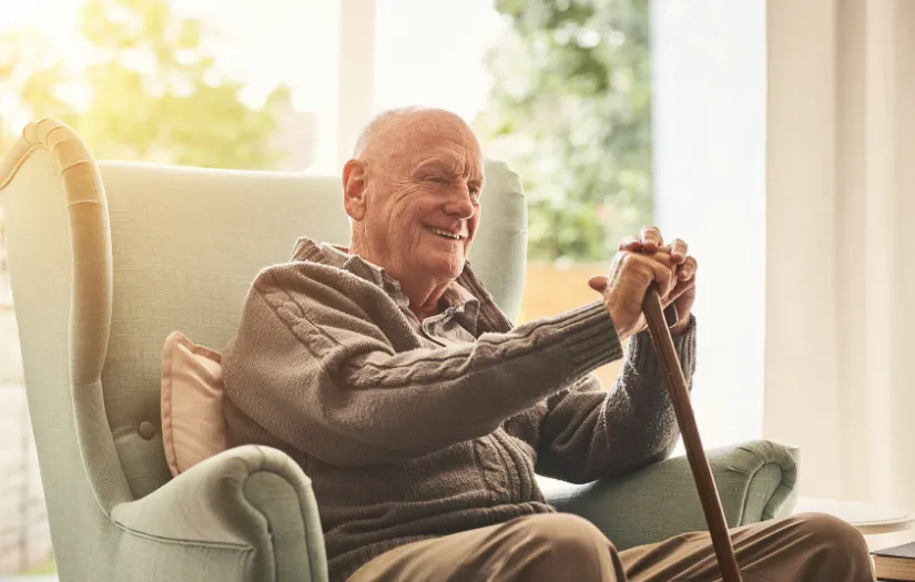 Elderly man smiling with cane representing safe medical appointment transportation for seniors