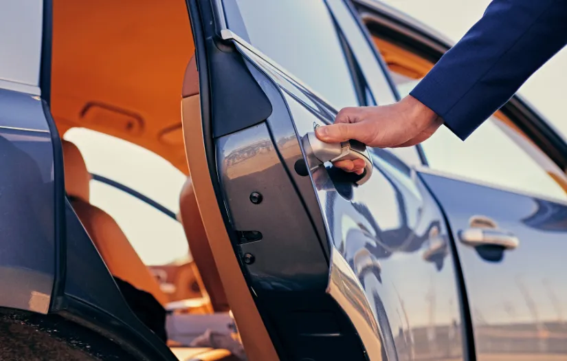 Professional chauffeur opening car door for secure and reliable transportation service