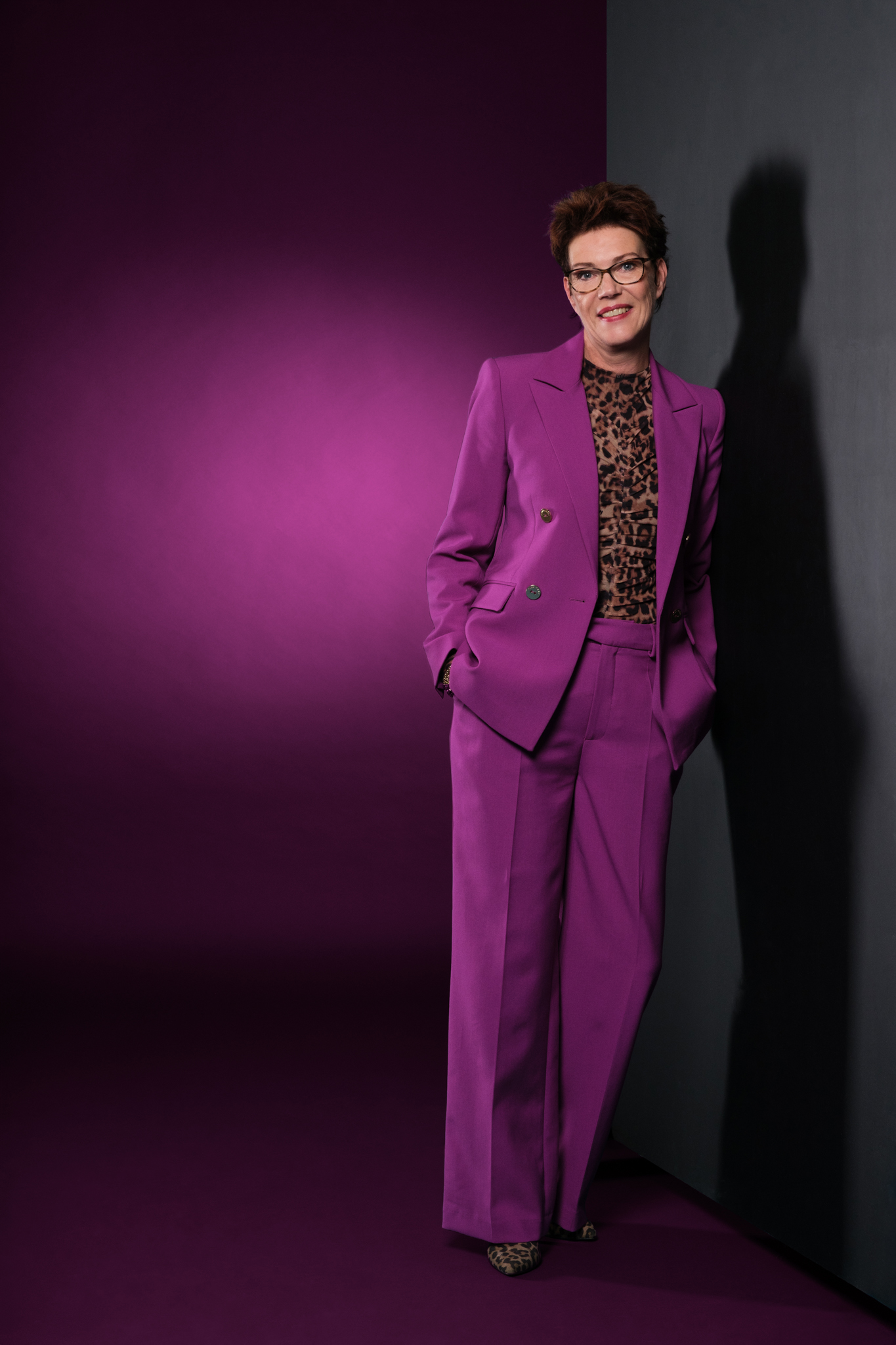 ondernemende vrouw in pak die met een sterke uitstraling op de foto staat