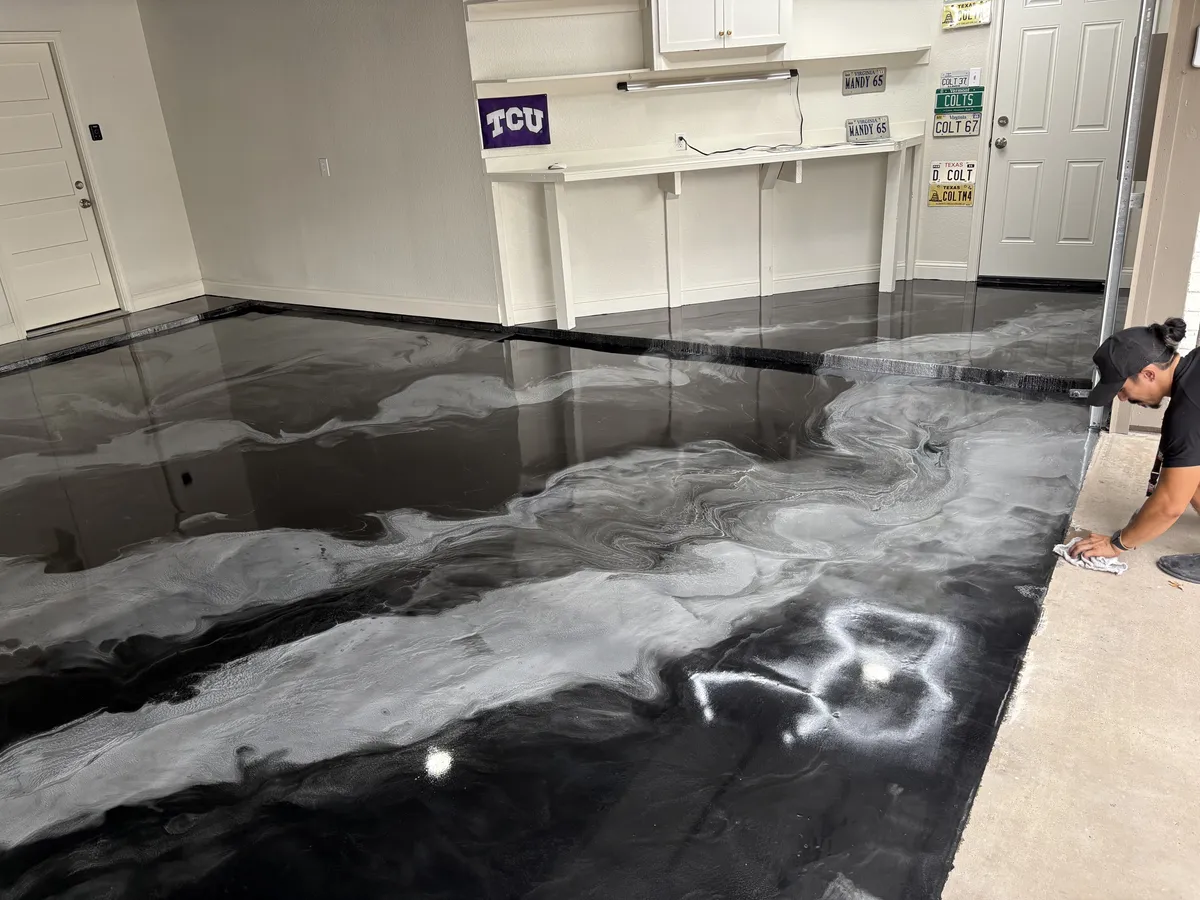 Black and white metallic epoxy garage floor being installed