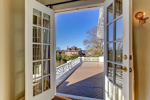 French doors installed by licensed Pure Windows contractors open to a sunny Cincinnati deck, showcasing custom American-made craftsmanship and reliable warranty-backed quality.