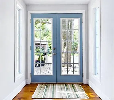 French doors with blue frames installed by Pure Windows in a Cincinnati home, providing wide access, abundant natural light, and elegant curb appeal—all with durable, climate-ready materials.