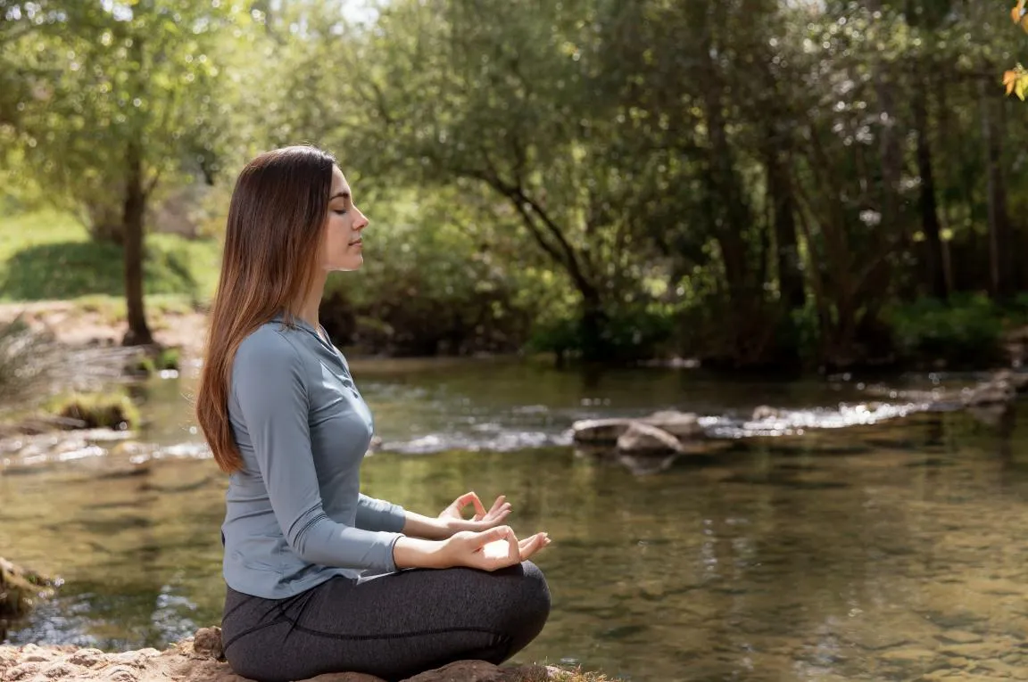 Lady meditating by a stream