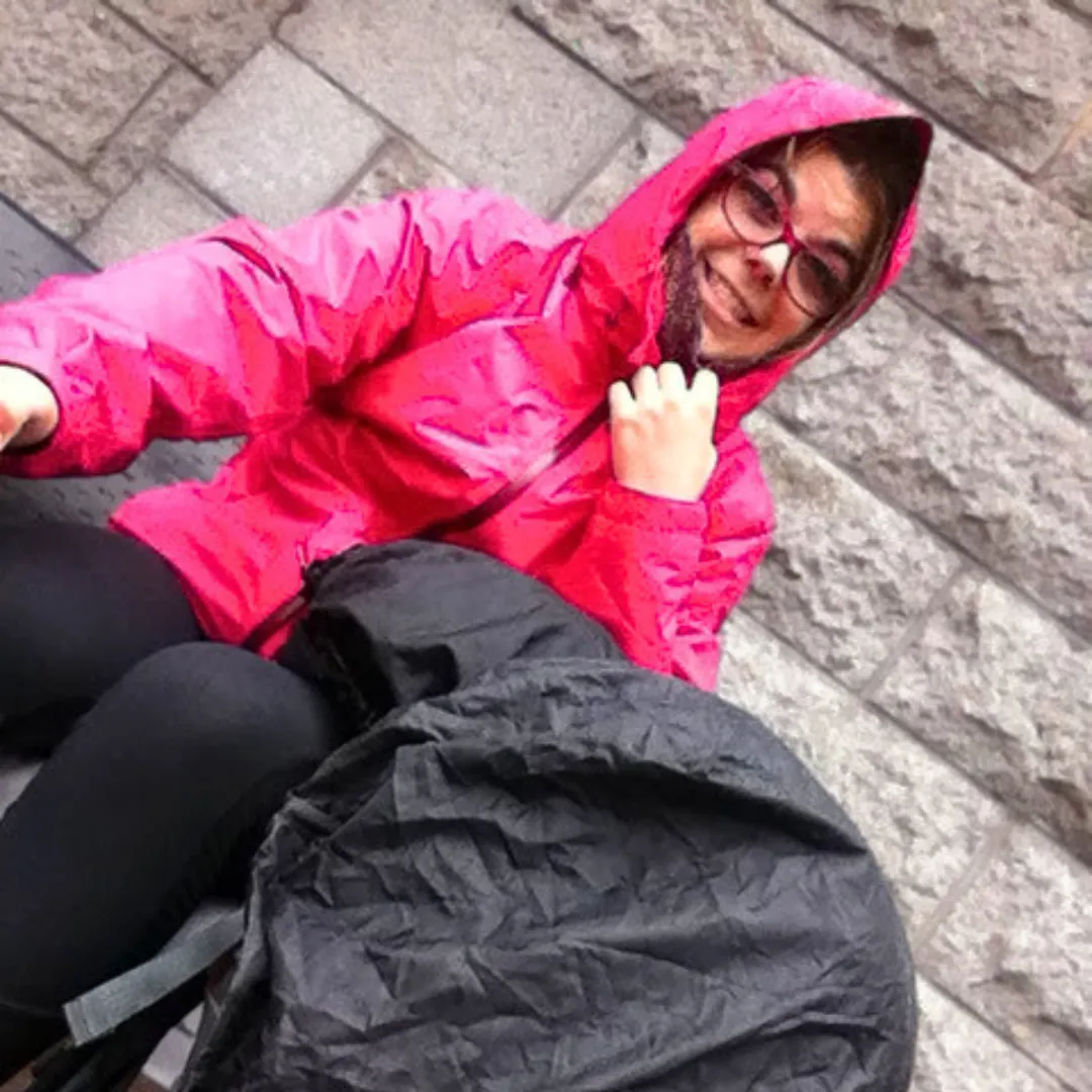 Catherine Perron assise sous la pluie en voyage en Europe