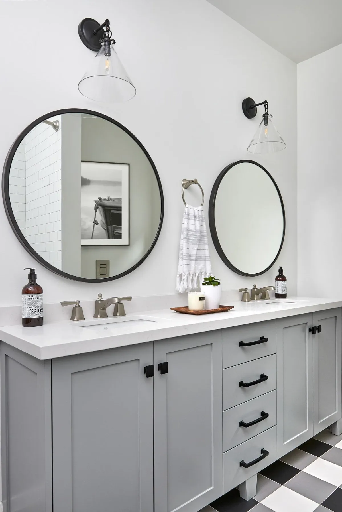 a bathroom with a double sink vanity and two round mirrors