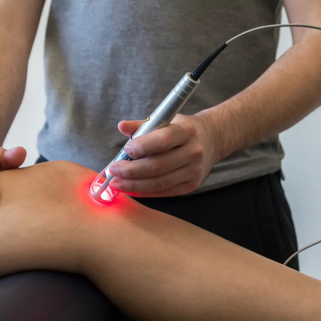 Laser therapy being performed on a patients knee and legs.