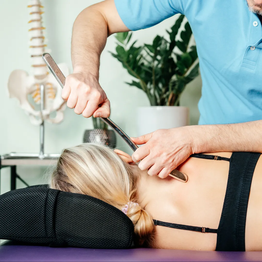 Chiropractor using a tool to release pressure in the back of a women