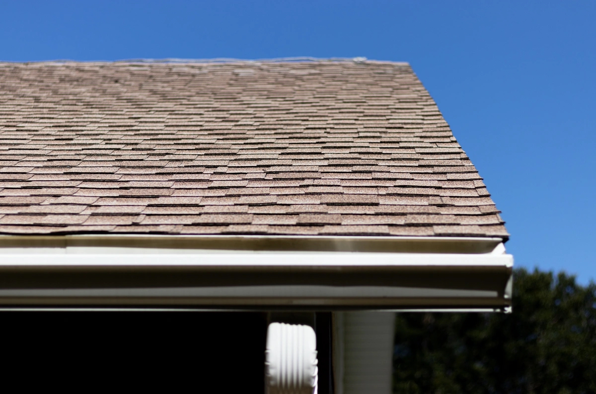 Roof replacement in Pelham Alabama showing asphalt shingles roofline detail and gutter system installed by Blackline Roofing