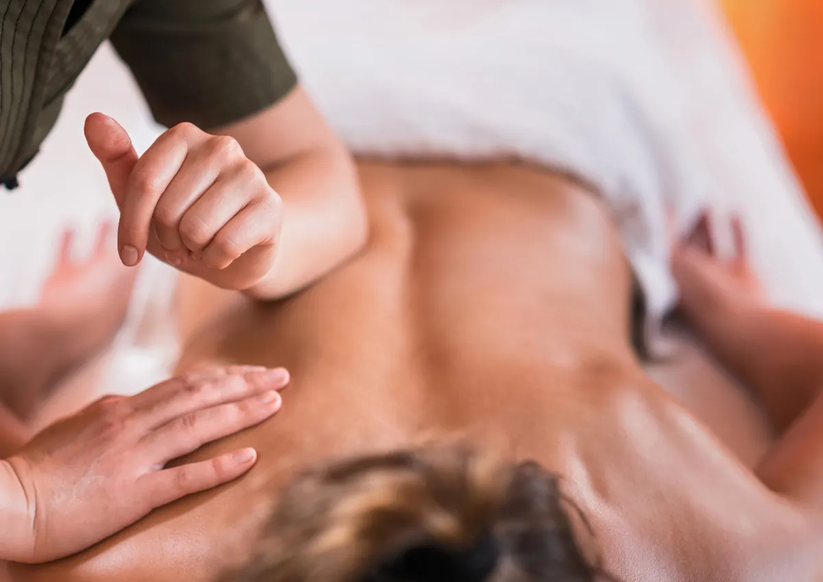 Professional massage treatment with appropriate draping and client comfort at Pause.