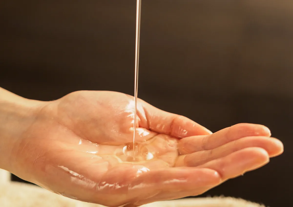 Massage oil poured onto therapist hand