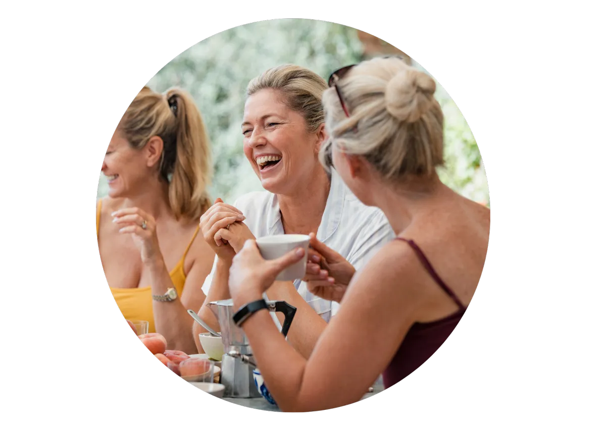 group of mature women sharing coffee and laughing