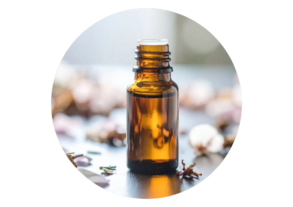 Aromatherapy oil in dark brown bottle surrounded by petals