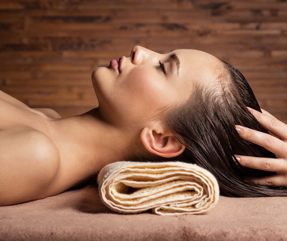 laying client receiving scalp massage
