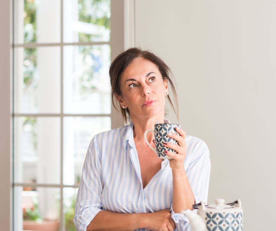 WOMAN THINKING HOLDING CUP OF TEA