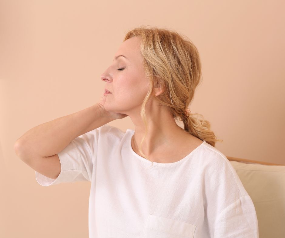blond woman looking tired with closed eyes, head to side and hand on neck