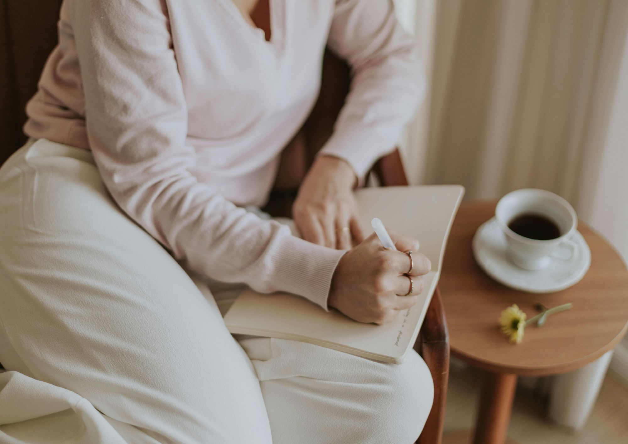 WOMAN WRITING IN NOTEBOOK BEFORE APPOINTMENT AT PAUSE, WEST NORFOLK