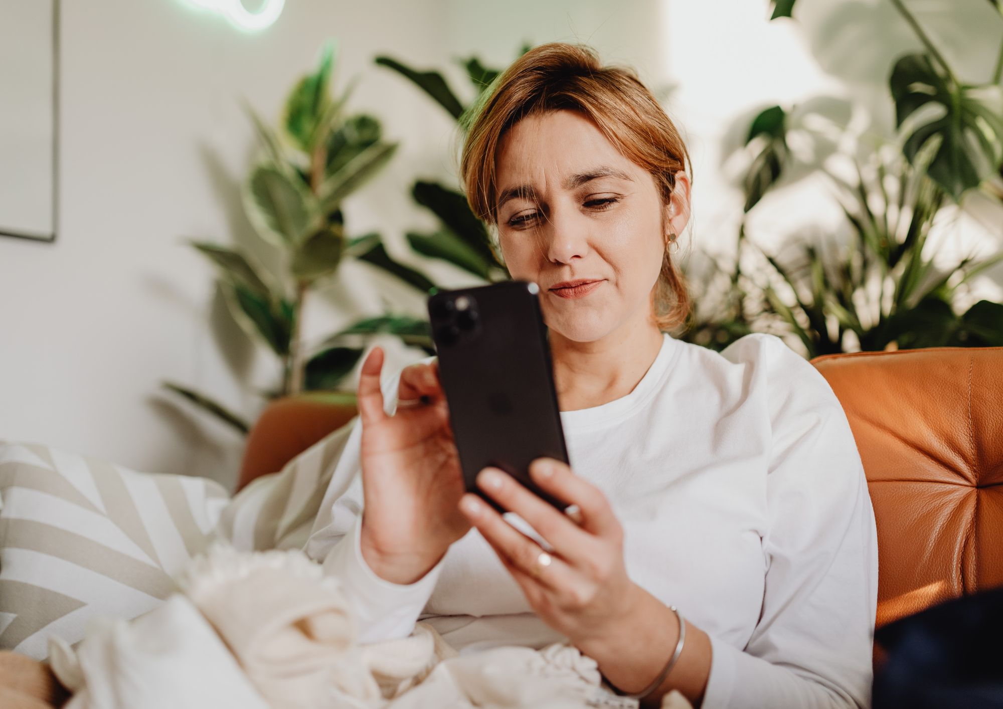 Woman looking on phone deciding which treatment to book at Pause Mind & Body Reset, Norfolk