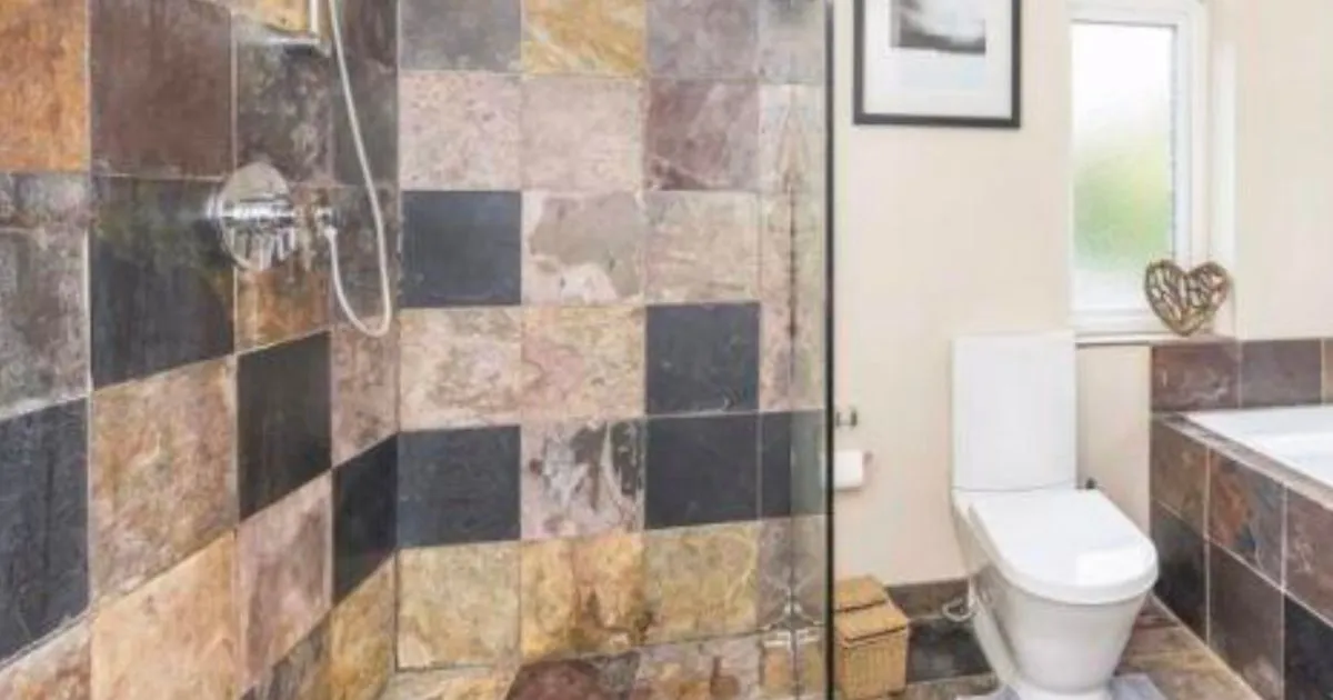 Tiled wet room and modern WC installed by CDI Contractors, featuring multicoloured Chinese slate tiles and a full height glass shower screen.