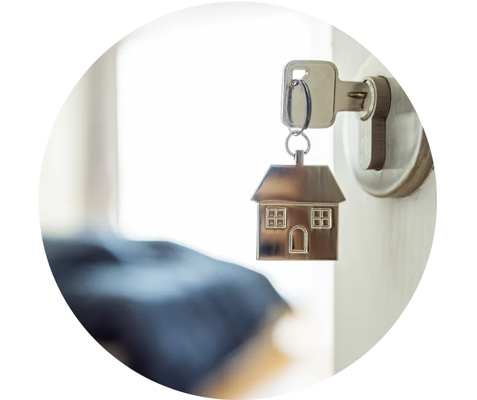 House-shaped keyring hanging from a door lock, representing rental properties, landlords and holiday accommodation.