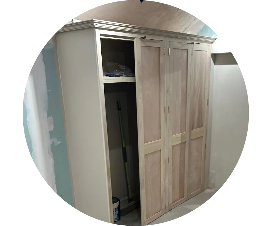 Bespoke fitted timber storage cupboards with panelled doors and overhead moulding, built by CDI Contractors to maximise available space.