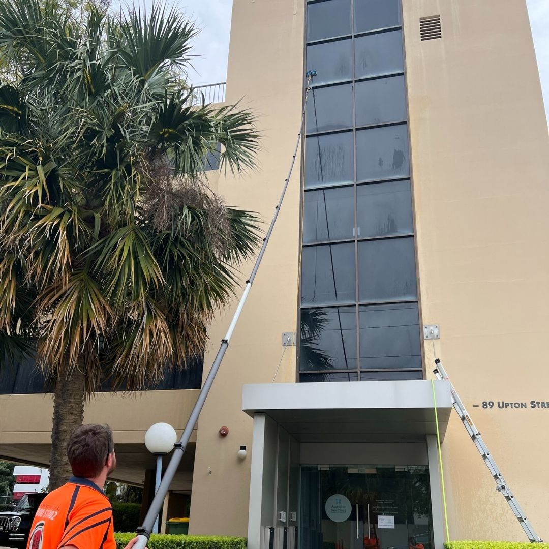 Water-fed pole reaching high windows on multi-storey Gold Coast building