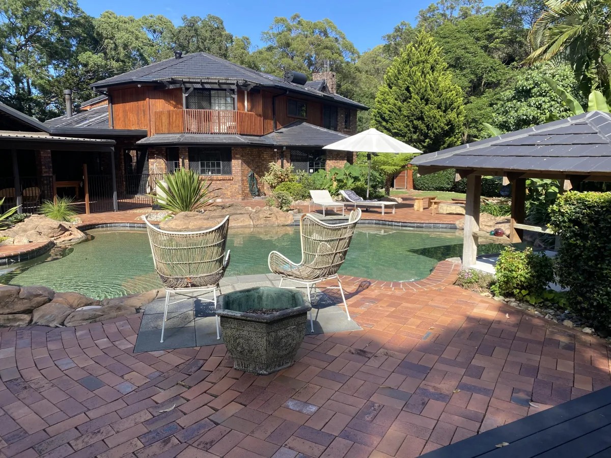 Professional retaining wall cleaning of a stone garden wall on the Gold Coast by Zen Window Cleaning.