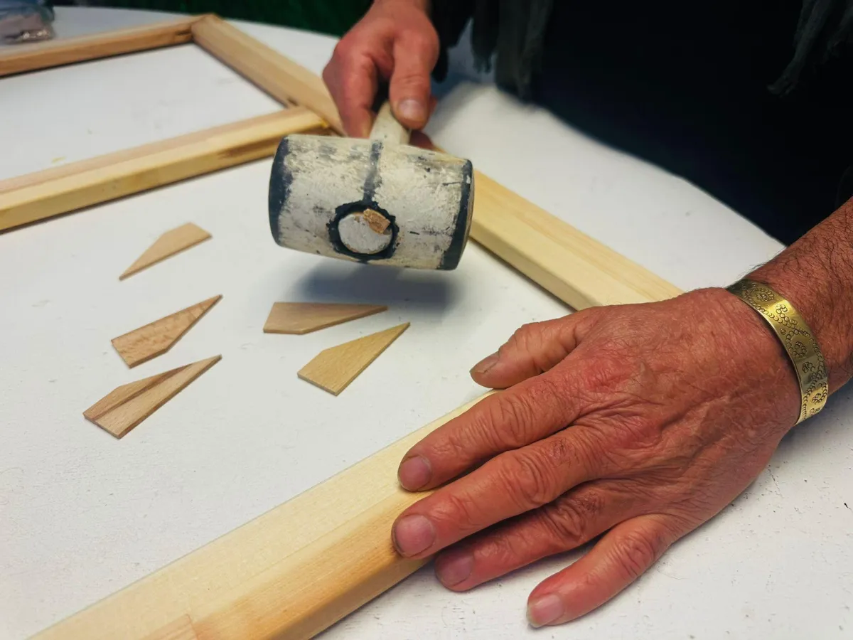 Links keilbarer Rahmen mit Holzkeilen und Schonhammer; rechts fix verleimter Strainer mit Leimflasche und Zwingen – Gegenüberstellung der Systeme.