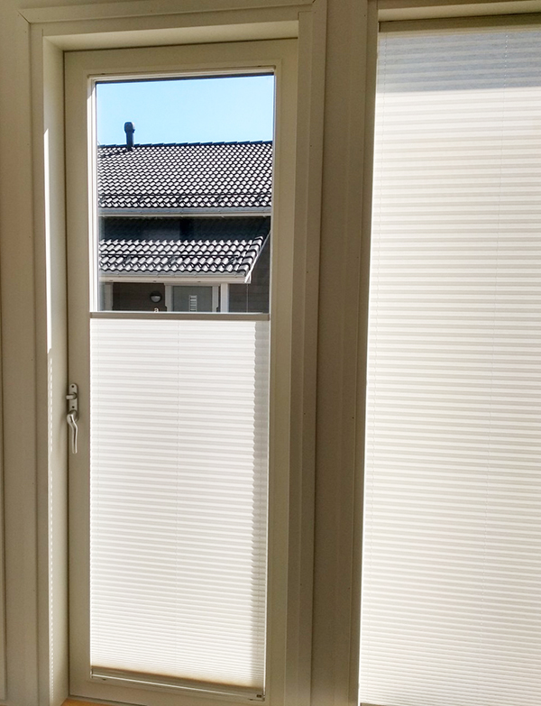 Valkoinen vekkiverho ikkunassa ja ovessa