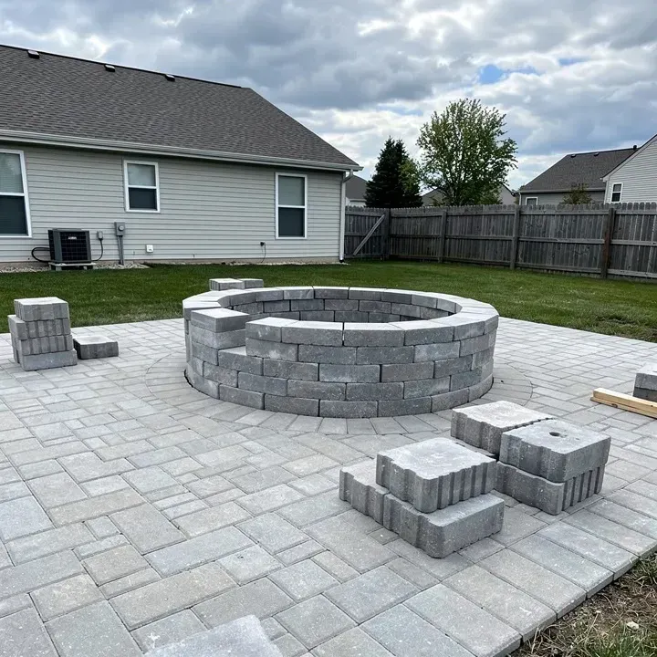 Paver fire pit installation in progress on a backyard patio in Beckett Ridge, Ohio