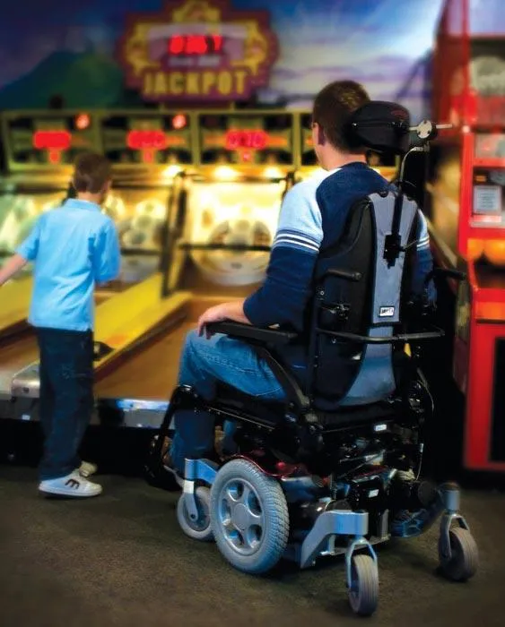man playing with son in a power wheelchair
