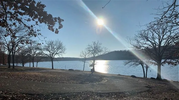 Calm lake in Cookson Hills with fishing boat and picnic shelter
