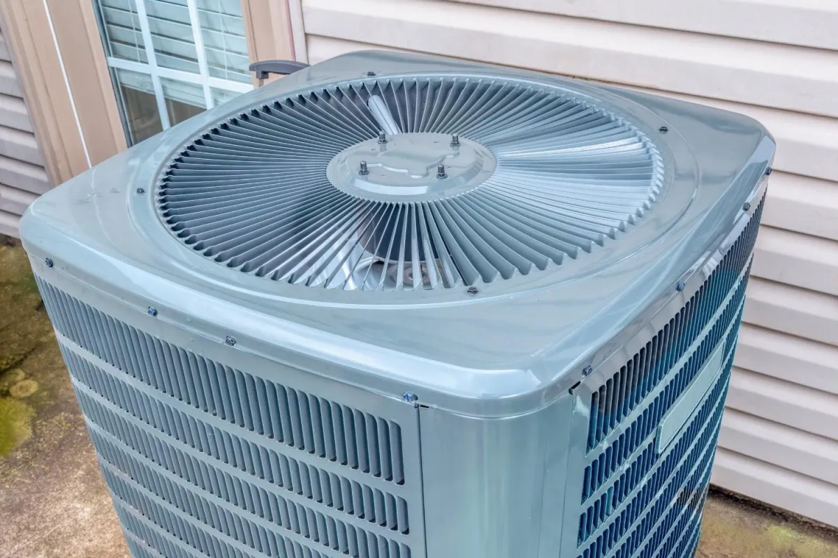 A large air conditioner positioned outside a residential home, providing cooling for the interior space.