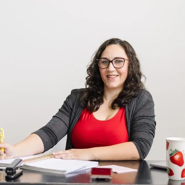 A woman wearing glasses and a green shirt, representing Emily Shetterly in a professional setting.