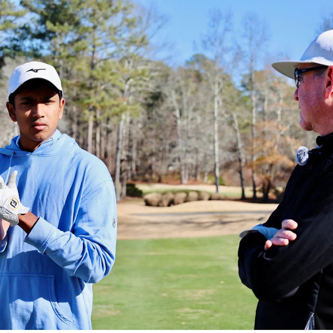 Ken Zinkand gives hole advice to college golfer