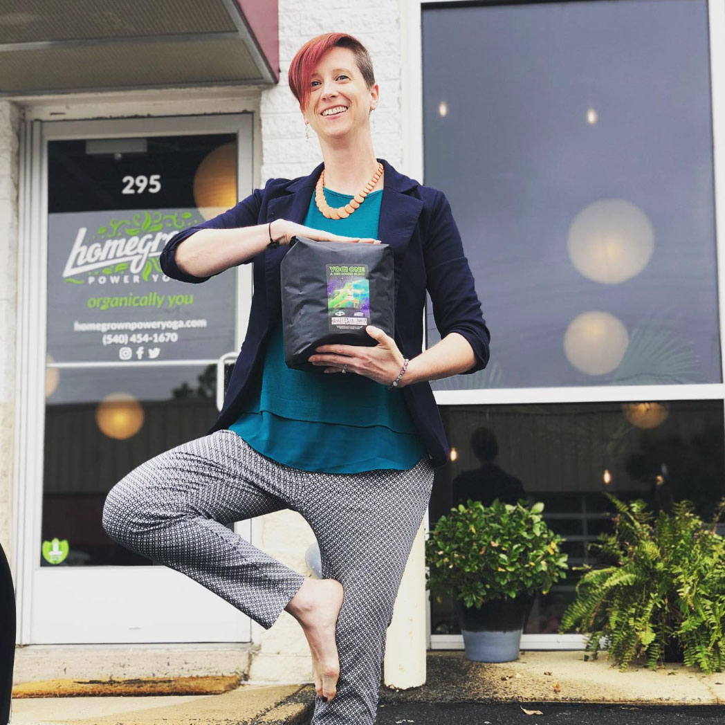 woman holding coffee in tree posese