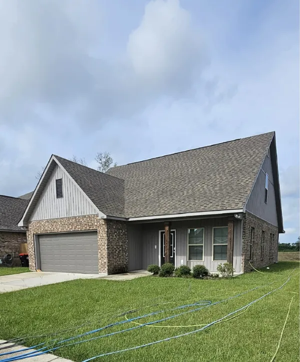  Neatly maintained modern brick and siding home with fresh green lawn.