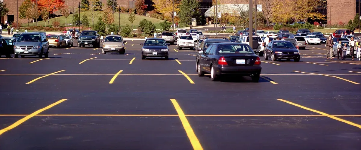 Crowded parking lot with bright yellow markings and multiple vehicles