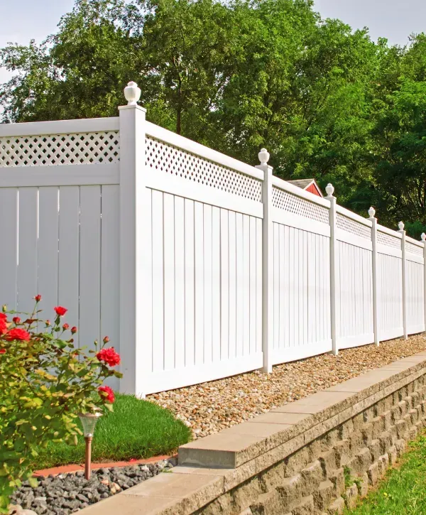  Decorative white vinyl privacy fence with lattice top and landscaped border.