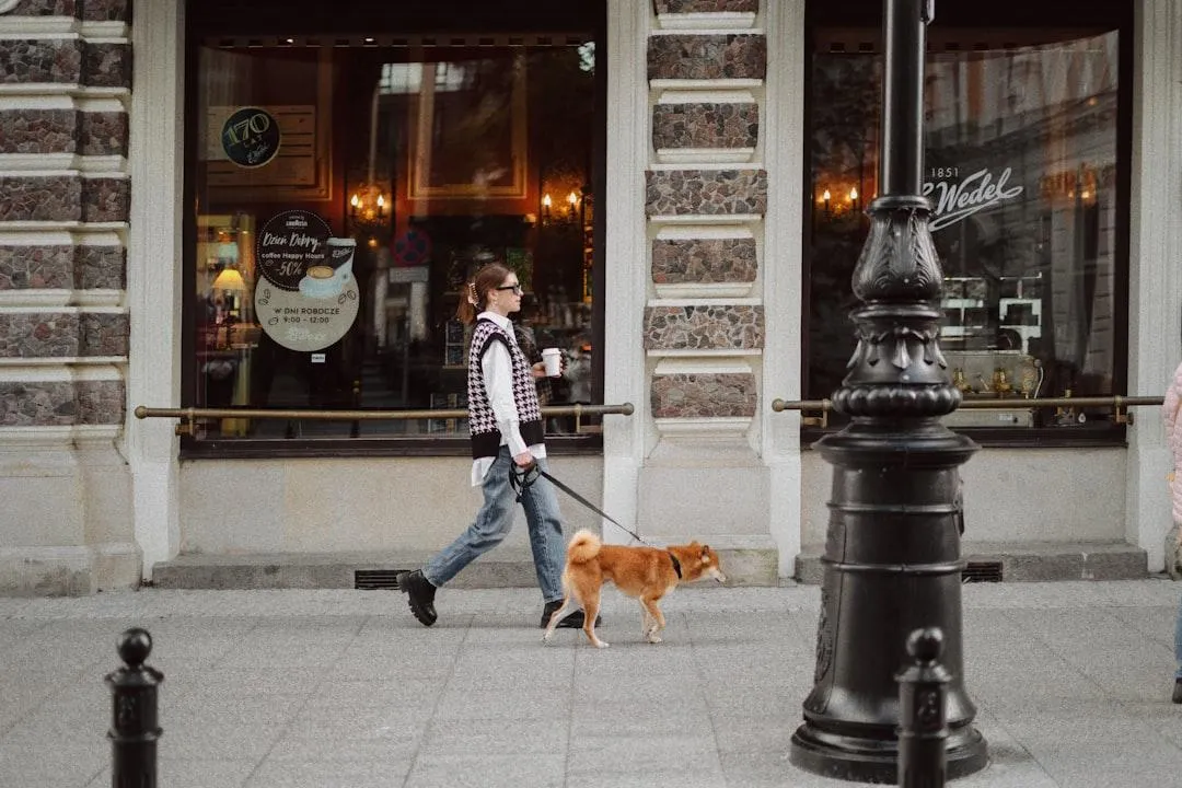 woman walking dog holding coffee