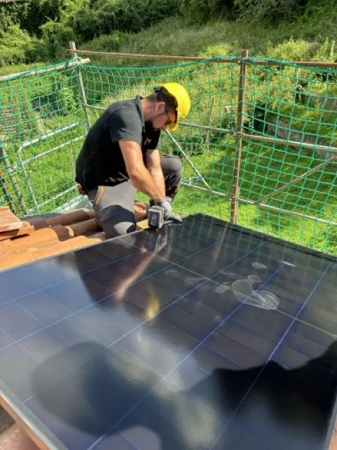Officina solare locale italiana con tecnici al lavoro e ricambi a portata di mano
