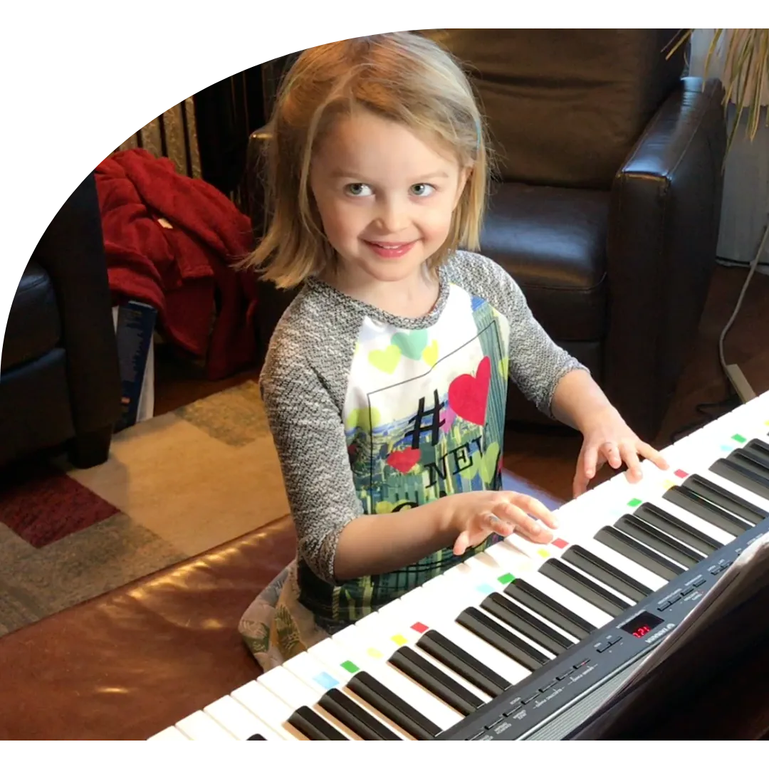 A girl smiling while playing a color-coded keyboard