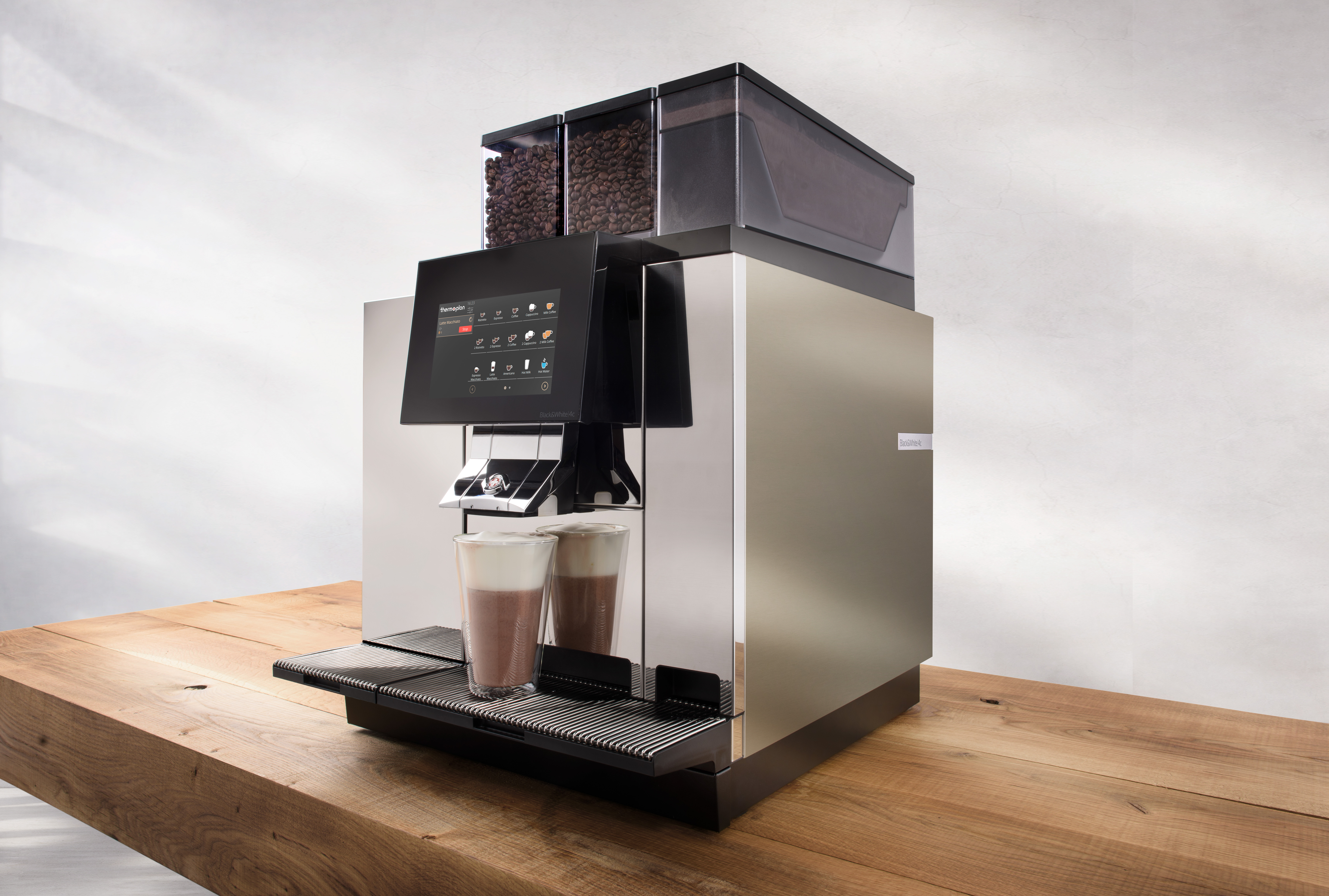 Thermoplan BW4c CTM P machine showing powder access and display, in a commercial kitchen/cafe setting, warm natural lighting.