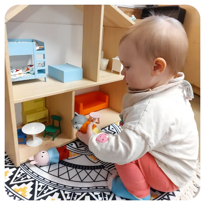 Infant playing with dolls house