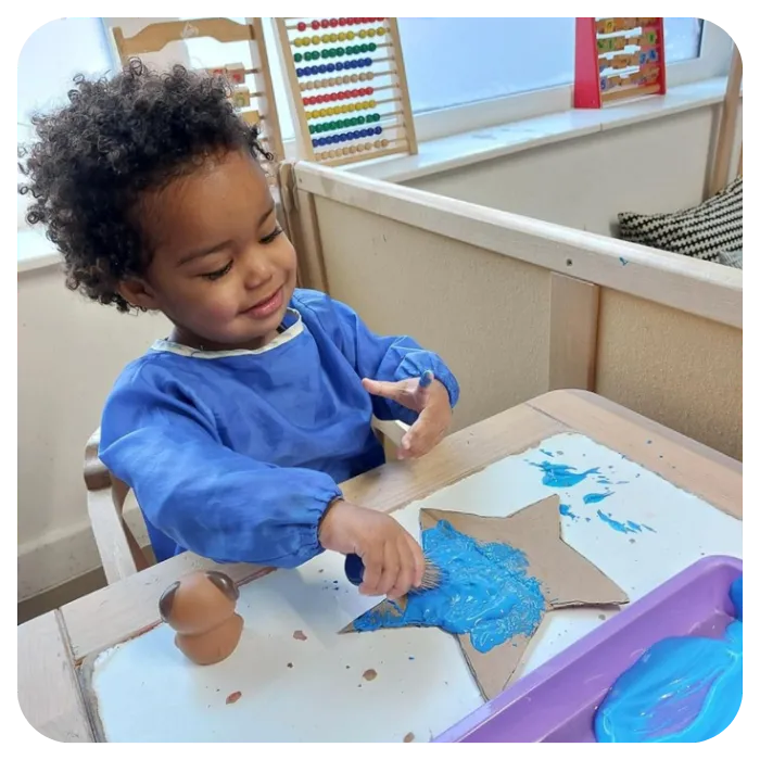 toddler doing arts and crafts in childcare